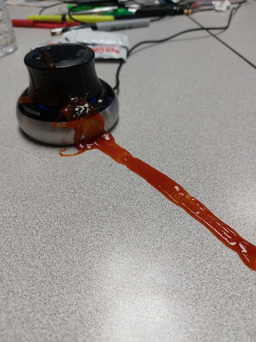 Ketchup packet squirted ketchup on my desk and Space Mouse.